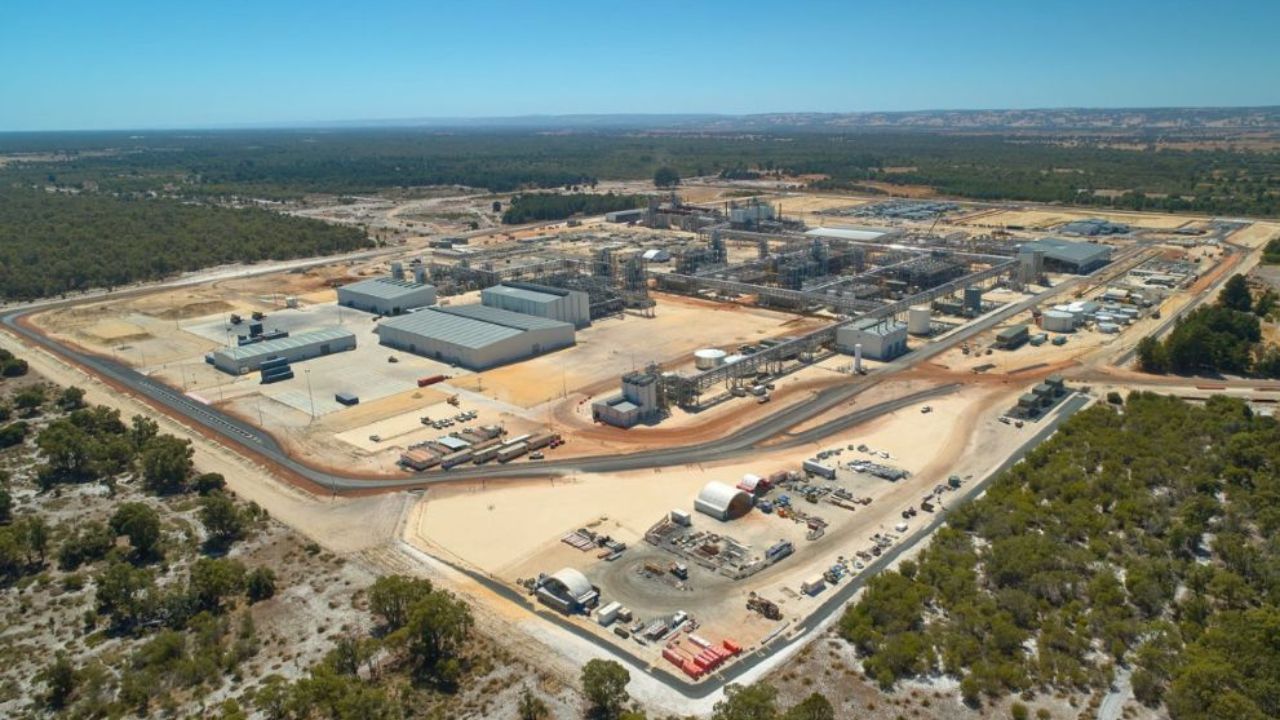 An aerial view of a lithium hydroxide processing plant comprising a large number industrial buildings, roads, pipes and overhead steel walkways