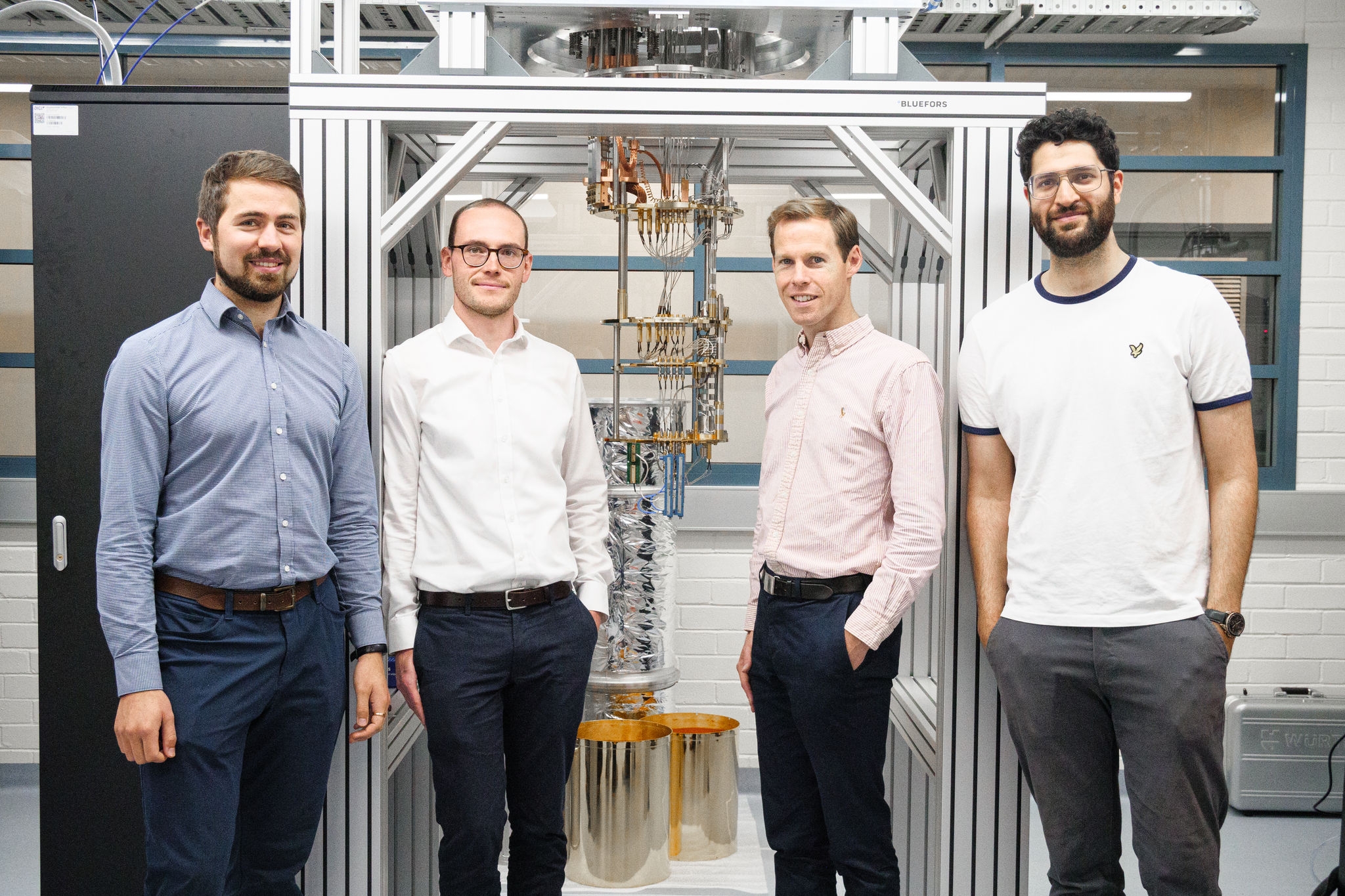 4 men standing in front of lab equipment