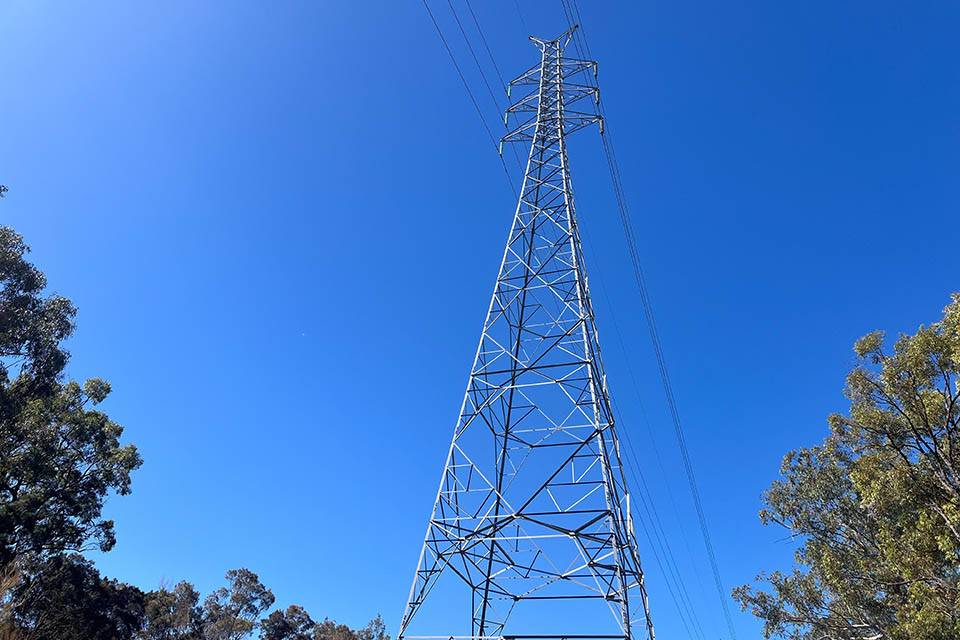 Tilt up motion over a tall transmission tower overhead power line.