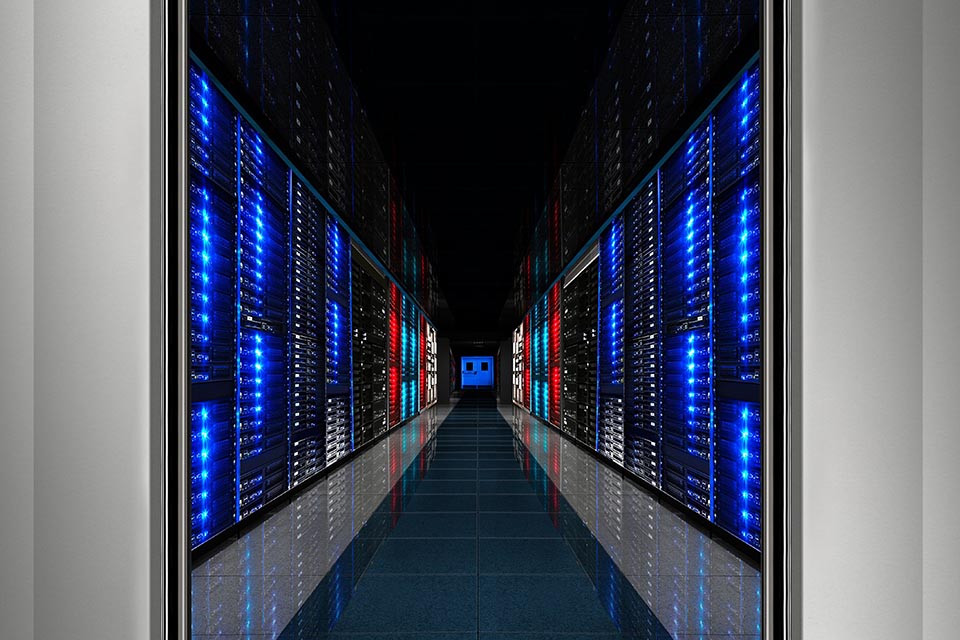 Long aisle, high ceiling Hi-Tech Data Center. Multi colored lights on server racks. Steel doors.