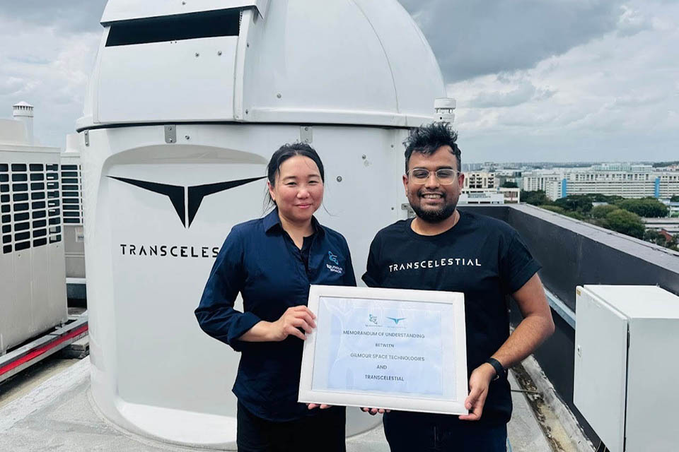 2 people holding a certificate in front of Transcelestial laser communications technology