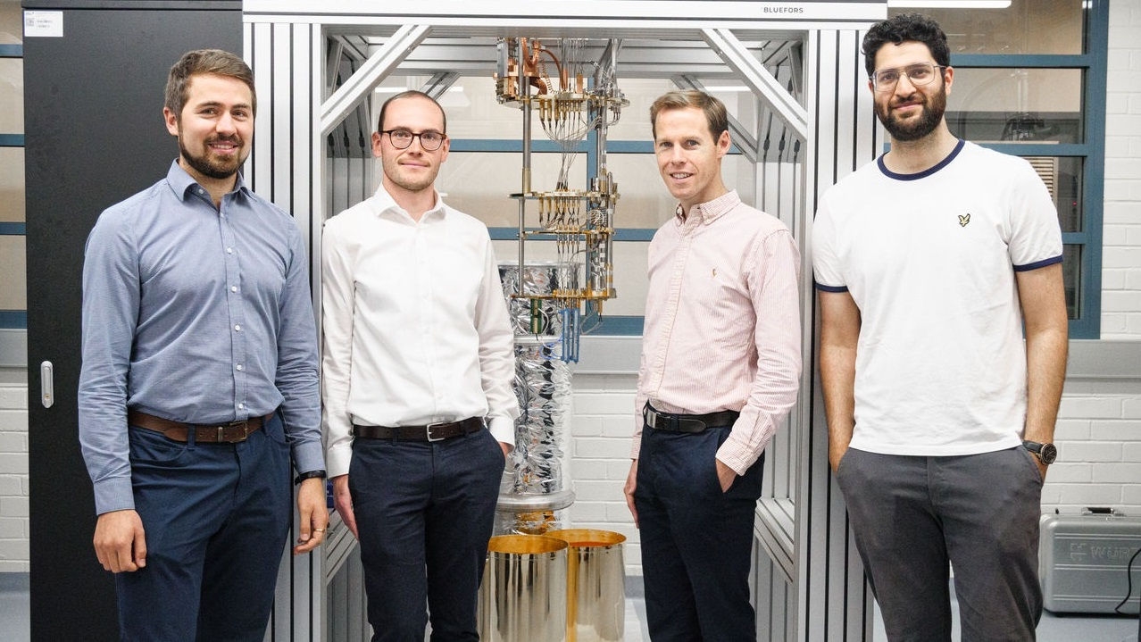 4 men standing in front of lab equipment