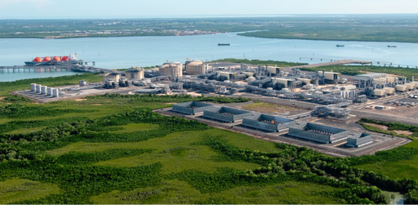 factory buildings by the coast surrounded by green landscape