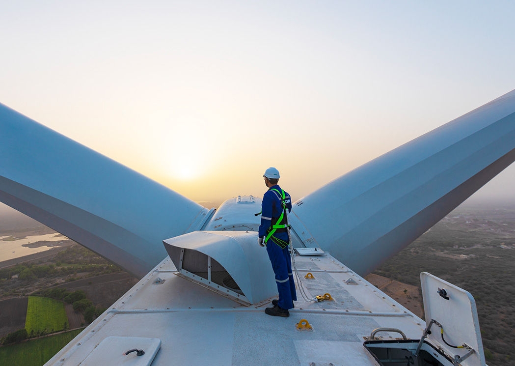 man standing on a wind turbine