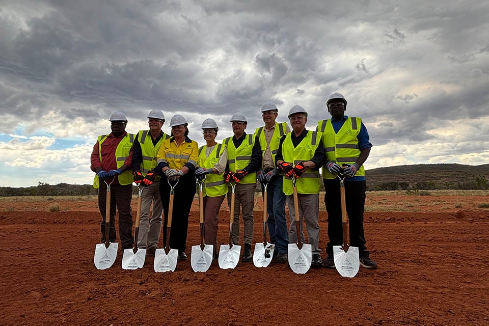 Group of people wearing high-vis vests holding shovels