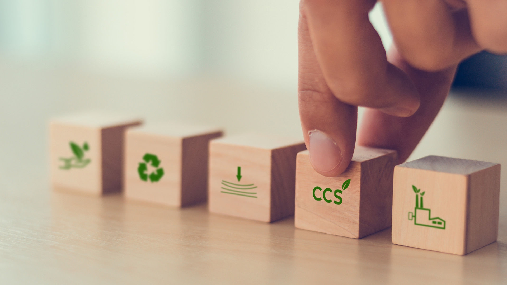 Concept image of fingers gripping a wooden block representing carbon capture and storage.