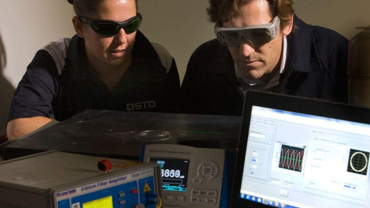 A female and male Defence scientists wear protective glasses during an experiment using a fibre laser