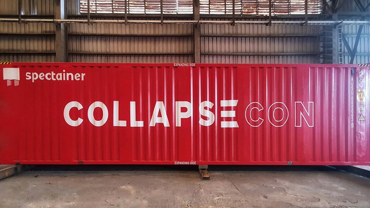 A red shipping container sits on a concrete floor in an industrial building