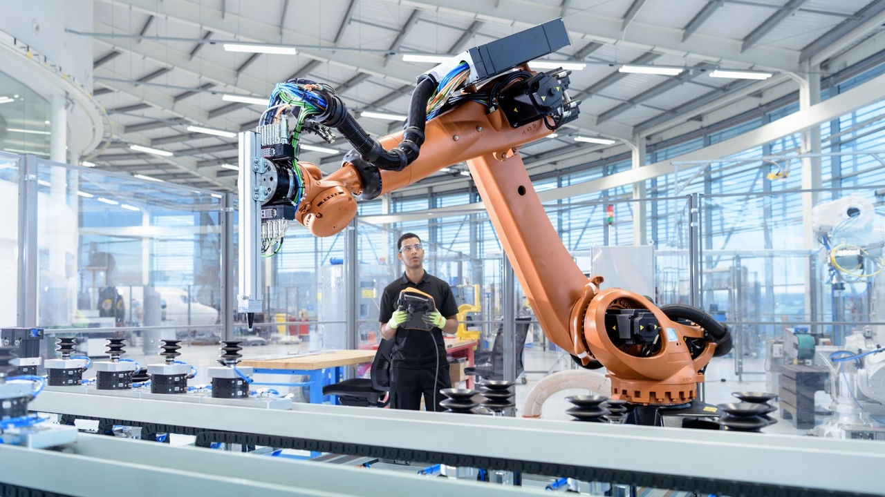 Engineer programming robot in a robotics research facility