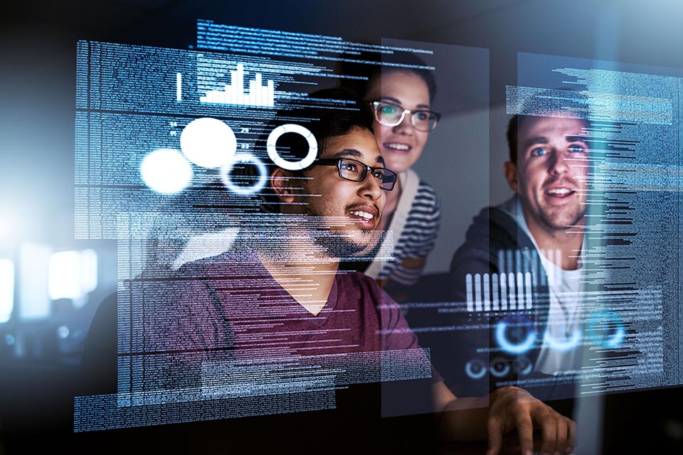 Reflection of 3 people looking at a computer screen containing script